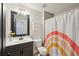 The bathroom features modern fixtures and a vibrant rainbow shower curtain at 5534 Radford Loop, Fairburn, GA 30213