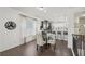A dining area features hardwood floors, a glass table, and access to a kitchen with bar seating and modern lighting at 5534 Radford Loop, Fairburn, GA 30213