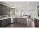 Modern kitchen featuring stainless steel appliances, gray cabinets, and a seamless flow to the living area at 5534 Radford Loop, Fairburn, GA 30213
