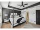 Comfortable main bedroom featuring a tray ceiling, dark accent wall, and modern furnishings at 5534 Radford Loop, Fairburn, GA 30213
