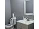 Small bathroom with gray vanity, toilet, and white sink at 7190 Buck Creek Dr, Fairburn, GA 30213