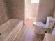 Bathroom with gray tile, vinyl flooring, and a tub at 2922 Eleanor Ter, Atlanta, GA 30318
