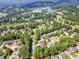 An aerial view displaying the neighborhood's beautiful mature trees, lake and golf course at 1004 Fairway Seven, Villa Rica, GA 30180