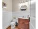 Powder room featuring wainscoting, wooden vanity and a decorative round mirror at 1004 Fairway Seven, Villa Rica, GA 30180