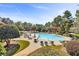 Community outdoor pool surrounded by manicured landscaping, seating and mature trees at 1004 Fairway Seven, Villa Rica, GA 30180