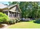 Relaxing sunroom with screened windows and a stone outdoor kitchen area, surrounded by a well-maintained lawn and trees at 1004 Fairway Seven, Villa Rica, GA 30180