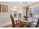 Cozy dining area with chandelier and view into the modern, white kitchen at 300 Huntington St, Covington, GA 30016