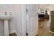 Modern powder room with pedestal sink and wood-look floors at 1756 Evenstad Way, Smyrna, GA 30080