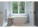 Luxurious bathroom with soaking tub, modern fixtures, and large window at 3244 Stillhouse Rd, Atlanta, GA 30339