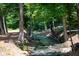 Serene stream flows through a wooded area beside a stone wall at 3244 Stillhouse Rd, Atlanta, GA 30339