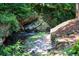 Stone pathway alongside a babbling brook, nestled in a lush forest setting at 3244 Stillhouse Rd, Atlanta, GA 30339