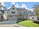 Two-story house with gray siding, brick accents, and a three-car garage at 216 Wakehurst Way, Marietta, GA 30064