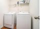 Bright laundry room with washer, dryer, and overhead shelving at 1328 Stone Bay Sw Dr, South Fulton, GA 30331