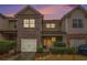 Charming townhome with brick and siding exterior, attached garage, and well-maintained landscaping at dusk at 1328 Stone Bay Sw Dr, South Fulton, GA 30331