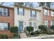 Two-story brick townhouse with blue door, landscaping, and steps leading to the entrance at 6412 Wedgeview Dr, Tucker, GA 30084