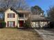 Two-story house with red accents, attached two-car garage, and a well-maintained lawn at 1402 Chelsea Downs Ne Ln, Conyers, GA 30013