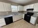 White cabinets, black appliances, and speckled countertops in this galley kitchen at 1402 Chelsea Downs Ne Ln, Conyers, GA 30013