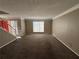 Living area with large window and neutral carpeting, view of the entryway at 1402 Chelsea Downs Ne Ln, Conyers, GA 30013