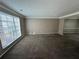 Spacious living room with large window and neutral carpeting at 1402 Chelsea Downs Ne Ln, Conyers, GA 30013