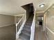 Entrance with staircase leading upstairs, view of kitchen and living room at 1402 Chelsea Downs Ne Ln, Conyers, GA 30013