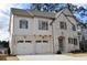 House exterior featuring brick and white accents, a three-car garage, and a charming front porch at 217 Wakehurst Way, Marietta, GA 30064