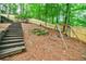 Wooded backyard with wooden stairs and swing set at 5490 Powers Overlook Ct, Atlanta, GA 30327