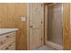Bathroom with shower and wood paneled walls at 3935 Loganville Hwy, Loganville, GA 30052
