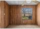 Simple bedroom with wood paneling, ceiling fan, and window at 3935 Loganville Hwy, Loganville, GA 30052