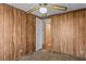 Bedroom with wood paneling, ceiling fan, and access to hallway at 3935 Loganville Hwy, Loganville, GA 30052