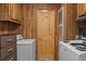 Small laundry room with washer, dryer and wood cabinets at 3935 Loganville Hwy, Loganville, GA 30052