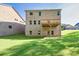 Rear exterior of home with brick, walkout basement, wood deck and a graded and sodded backyard at 741 Cams Crk, Mcdonough, GA 30253