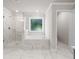 Bathroom featuring a glass shower, tub under the window, and marble-style tile at 741 Cams Crk, Mcdonough, GA 30253