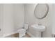 Bathroom features a pedestal sink, toilet, mirror and hardwood floors at 741 Cams Crk, Mcdonough, GA 30253