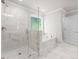 Bathroom featuring a glass shower, tub under the window, and marble-style tile at 741 Cams Crk, Mcdonough, GA 30253