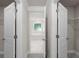 Hallway view with open doors and a glimpse into the bathroom featuring a tub and window at 741 Cams Crk, Mcdonough, GA 30253