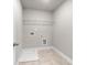Tiled laundry room with white wire shelving, appliances, and white trim at 741 Cams Crk, Mcdonough, GA 30253
