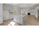 Open-concept kitchen and living room with gray cabinets, granite countertops, fireplace, and hardwood floors at 741 Cams Crk, Mcdonough, GA 30253