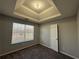 Bright bedroom with tray ceiling, window, and carpet at 916 Brisley Cir, Hampton, GA 30228
