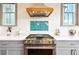 Modern kitchen with stainless steel range and custom wood vent hood at 2188 Niles Pl, Atlanta, GA 30324