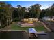 Modern lakefront home with lighted pool and private dock at dusk at 2746 Emerald Dr, Jonesboro, GA 30236