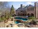 Expansive brick home with a multi-level backyard pool, stone patios, and lush landscaping at 4755 Riverview Rd, Atlanta, GA 30327