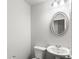 Small bathroom with white pedestal sink and oval mirror at 425 Camella Cir, Mcdonough, GA 30252