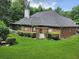 Brick house with screened porch, arbor, and lush lawn at 3957 Birdie Dr, Douglasville, GA 30134