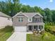 Two-story house with gray brick exterior, white garage door, and front porch at 1805 Wellston Dr, Lawrenceville, GA 30043