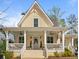 Charming yellow farmhouse with wraparound porch and landscaped yard at 11190 Serenbe Ln, Chattahoochee Hills, GA 30268