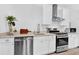 Modern white kitchen with stainless steel appliances and light countertops at 11190 Serenbe Ln, Chattahoochee Hills, GA 30268