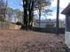 Partially fenced backyard with mature trees and neighbor's house visible at 1193 Kelton Dr, Stone Mountain, GA 30083