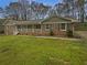 Charming brick home featuring a long porch with classic columns and a beautifully maintained lawn at 2082 Rainbow Dr, Snellville, GA 30039
