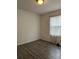 Simple bedroom with large window and wood-look floors at 16103 Waldrop Cv, Decatur, GA 30034