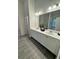 Double vanity bathroom with a large mirror and grey tile floor at 4005 Riverchess Lot 127 Sw Dr, Atlanta, GA 30331